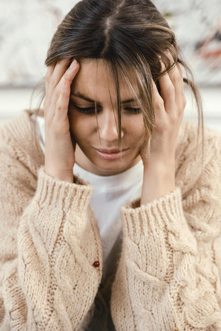 a woman holding her head in her hands in distress