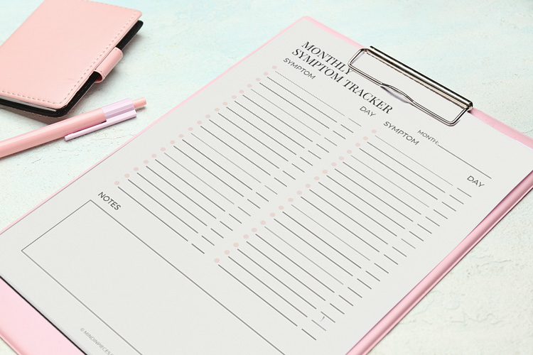 a clipboard with a monthly symptom tracker printable